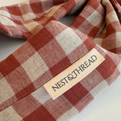 Rust and natural linen checkered fabric with a label on a white background